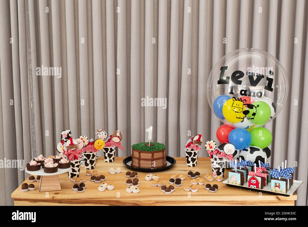 Table à gâteau d'anniversaire rustique pour enfants avec ferme, gâteau de campagne et bonbons. Fête d'anniversaire des enfants avec ballons et décorations à l'intérieur Banque D'Images