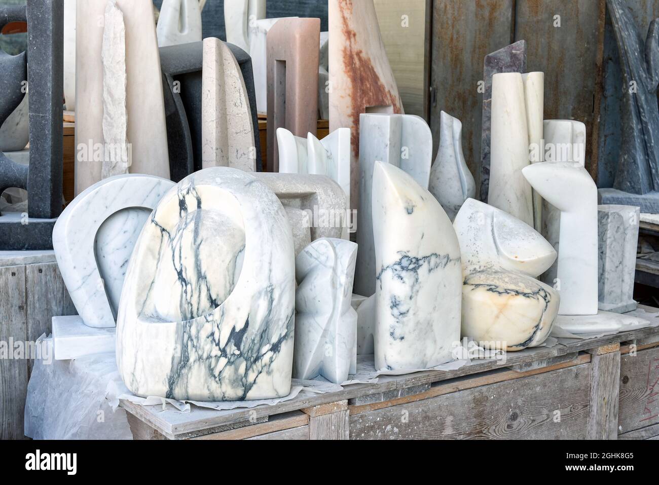 Assortiment de statues en marbre italien blanc abstrait Carrara exposées sur un banc dans un atelier pour la décoration intérieure et extérieure Banque D'Images
