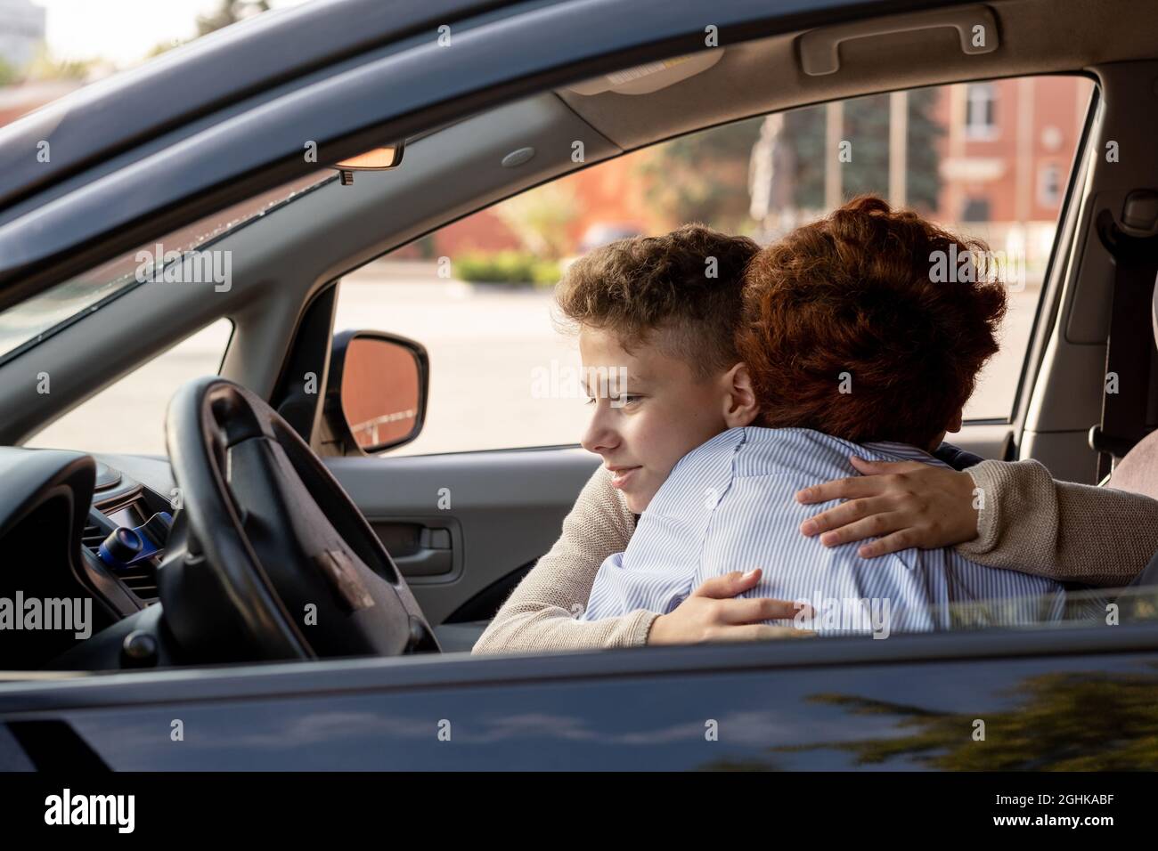 Un écolier embrasse sa mère dans la voiture avant d'aller à l'école le matin Banque D'Images