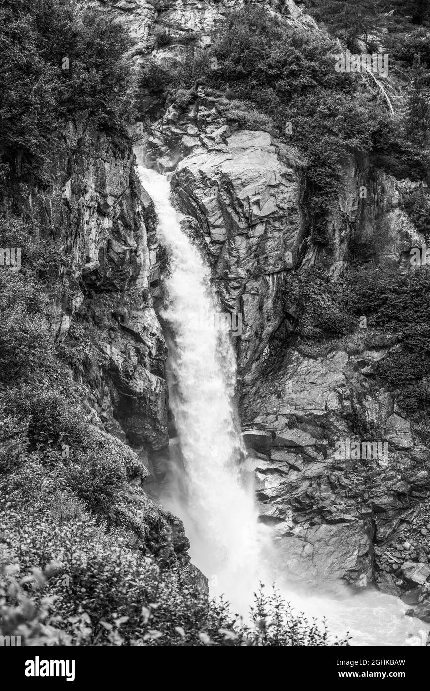 Cascade alpine sauvage sur le ruisseau de montagne de Schlatenbach. Vallée de Gschloesstal, parc national Hohe Tauern, Tyrol oriental, Alpes autrichiennes. Image en noir et blanc. Banque D'Images