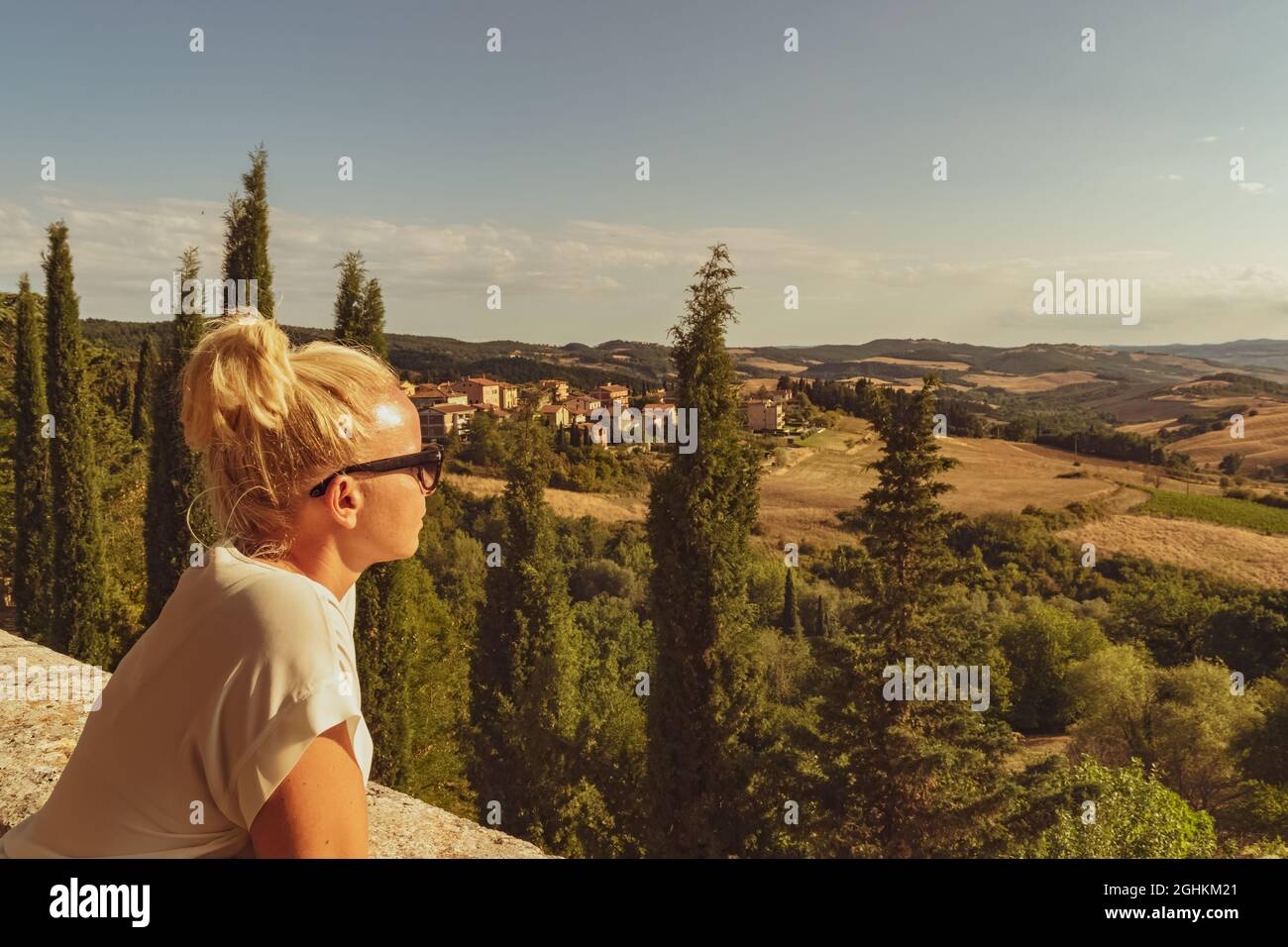 Toscane, Italie. Belle fille blonde regardant un paysage typiquement toscan. Une image impressionnante pour l'usage que vous voulez en faire. Banque D'Images