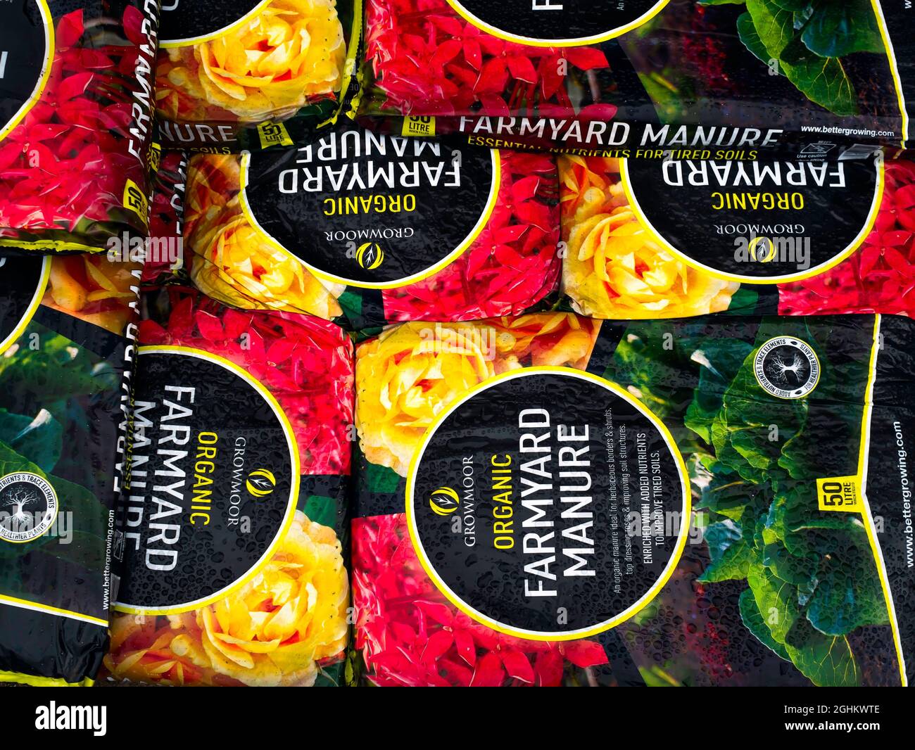 Une pile de sacs de fumier de ferme l'amélioration de la qualité des sols et la promotion de la croissance des plantes en vente dans un centre de jardinage Banque D'Images