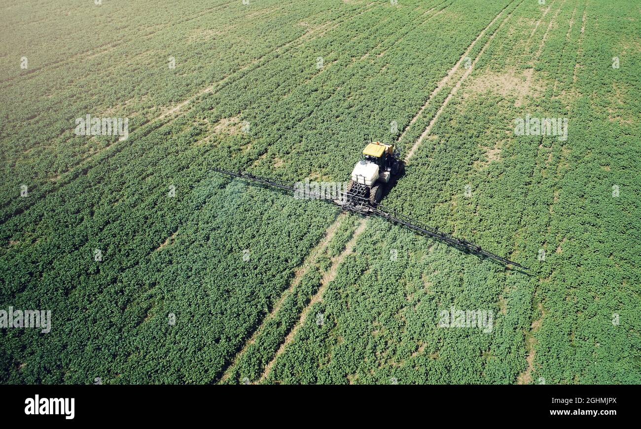 Terres agricoles cultivées avec des tracteurs pulvérisent des pesticides au-dessus de la vue de dessus de drone Banque D'Images Terres agricoles cultivées avec des tracteurs pulvérisent des pesticides au-dessus de la vue de dessus de drone Banque D'Images