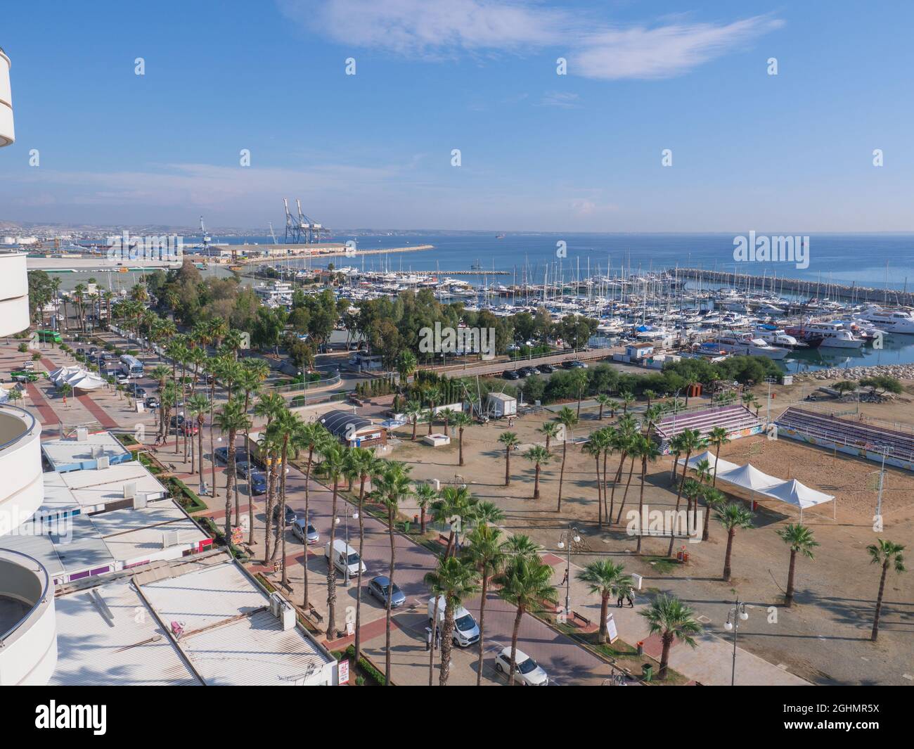 Vue aérienne sur la promenade de Finikoudes avec palmiers, yachts dans le port et terrain de volley-ball sur la plage méditerranéenne lors d'une journée ensoleillée Banque D'Images