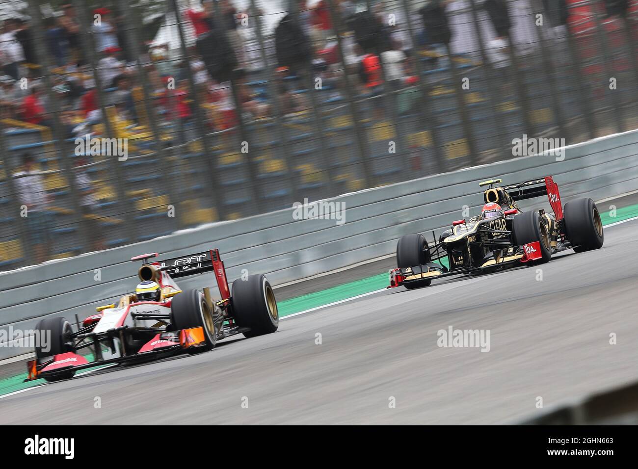 Pedro de la Rosa (ESP) HRT Formule 1 l'équipe F112 dirige Romain Grosjean (FRA) Lotus F1 E20 peu de temps avant qu'ils aient pris contact pour se qualifier. 24.11.2012. Championnat du monde de Formule 1, Rd 20, Grand Prix brésilien, Sao Paulo, Brésil, Jour de qualification. Banque D'Images