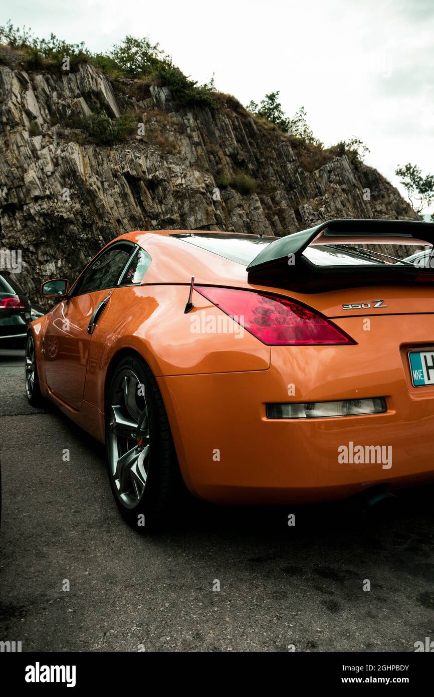 Orange Nissan 350z stationné sur une route à l'extérieur d'un restaurant Banque D'Images