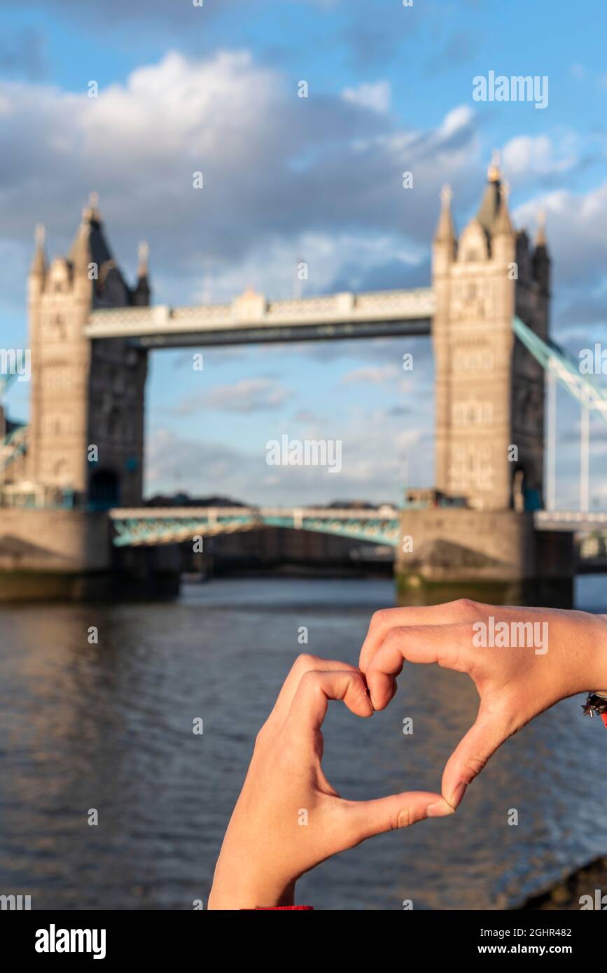 Les mains forment un coeur, derrière Tower Bridge au-dessus de la Tamise, Londres, Angleterre, Grande-Bretagne Banque D'Images