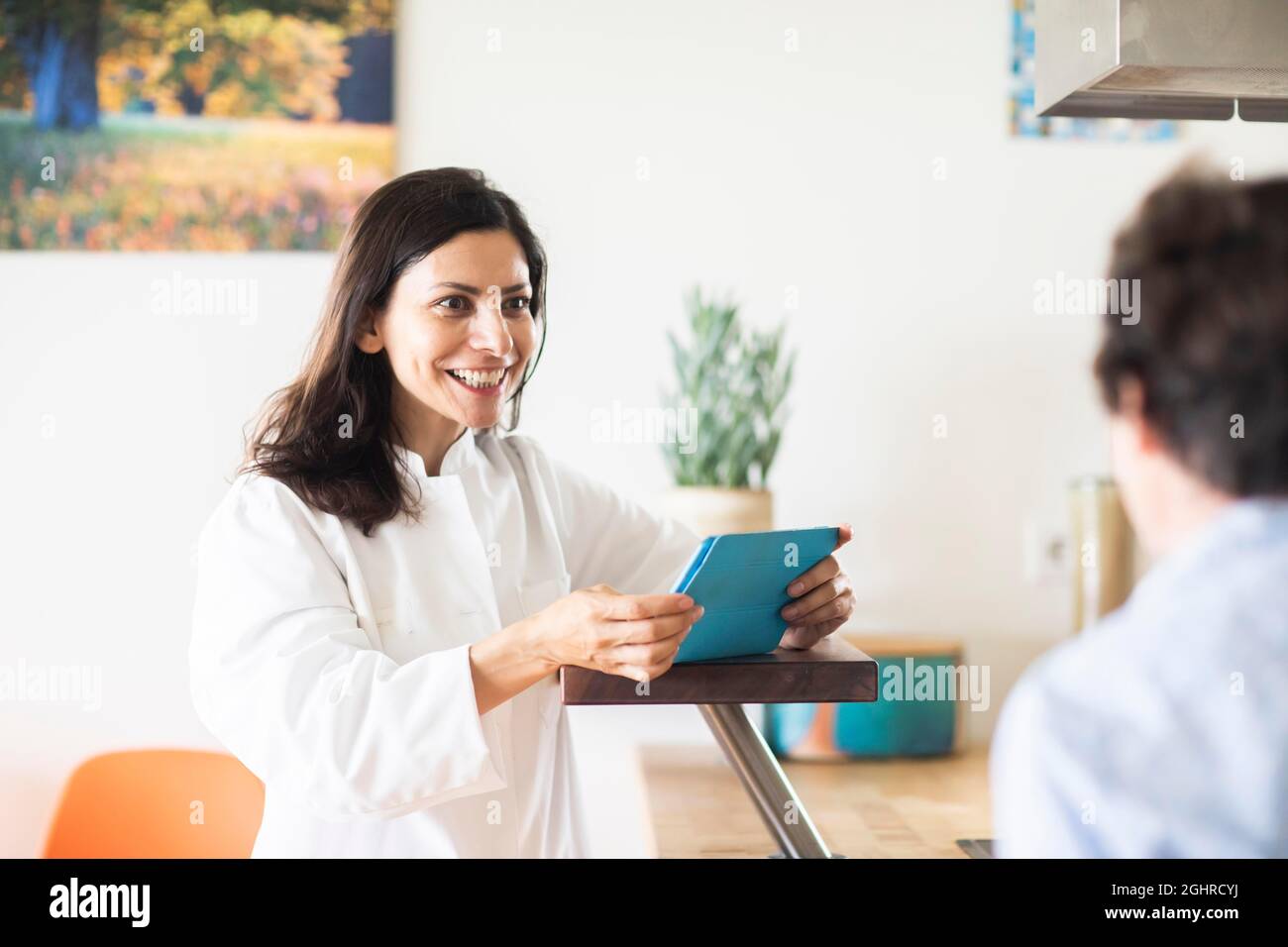 Médecin dans un cabinet avec comprimé et patient, Fribourg, Bade-Wurtemberg, Allemagne Banque D'Images