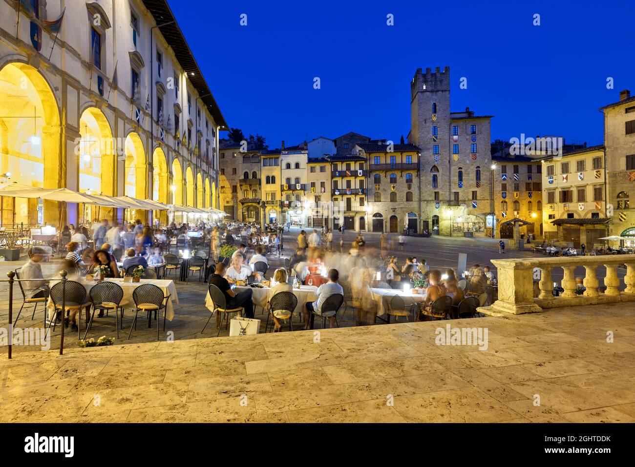 Arezzo Toscane Italie. Piazza Grande au coucher du soleil. Les gens mangent dehors Banque D'Images
