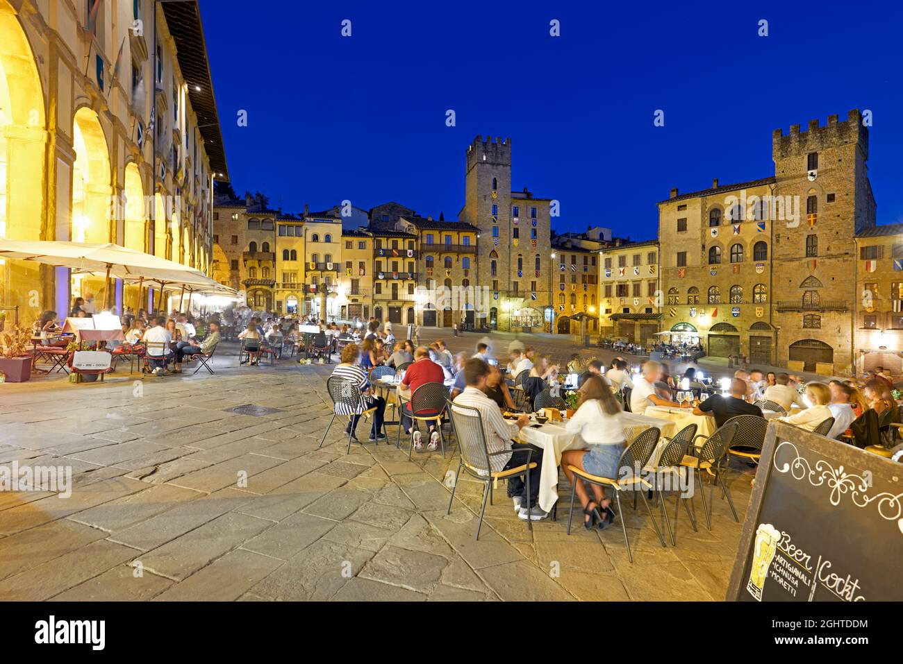Arezzo Toscane Italie. Piazza Grande au coucher du soleil. Les gens mangent dehors Banque D'Images