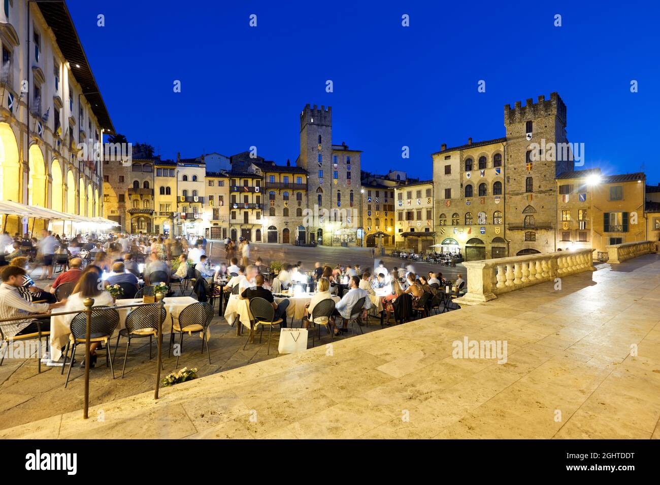 Arezzo Toscane Italie. Piazza Grande au coucher du soleil. Les gens mangent dehors Banque D'Images