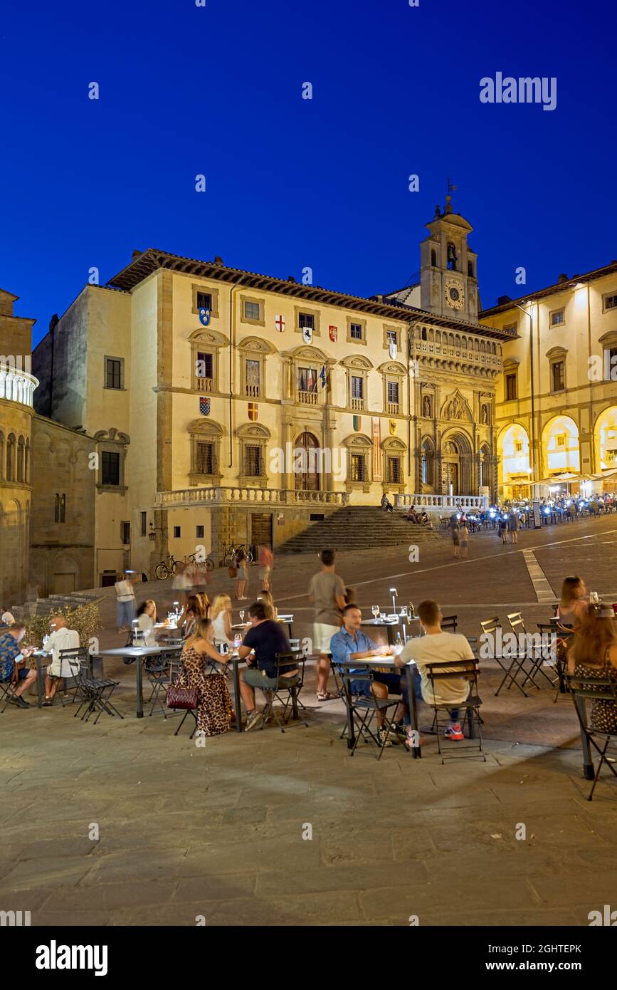 Arezzo Toscane Italie. Piazza Grande au coucher du soleil. Les gens mangent dehors Banque D'Images