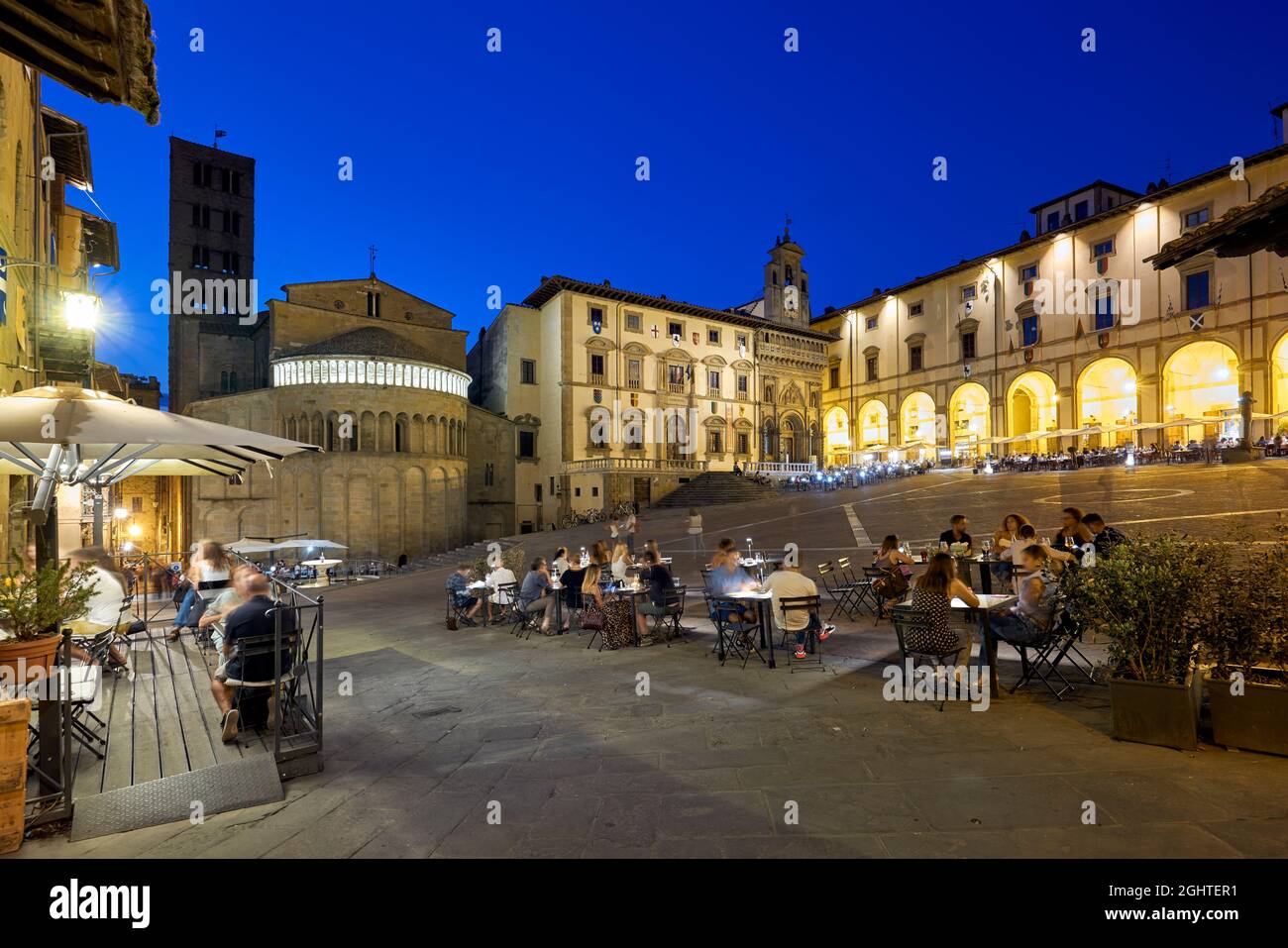 Arezzo Toscane Italie. Piazza Grande au coucher du soleil. Les gens mangent dehors Banque D'Images