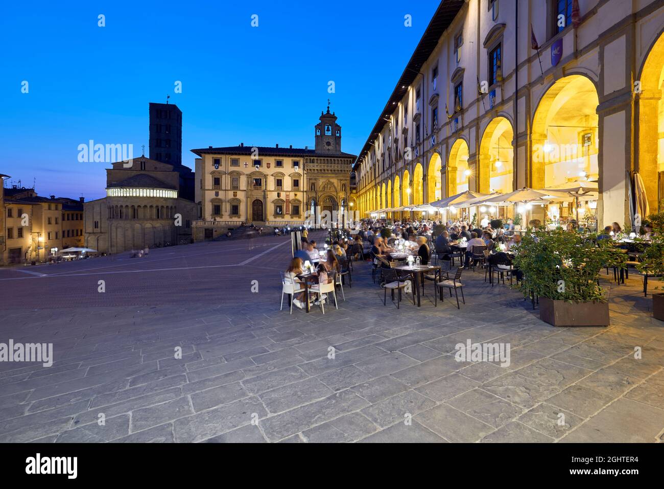 Arezzo Toscane Italie. Piazza Grande au coucher du soleil. Les gens mangent dehors Banque D'Images
