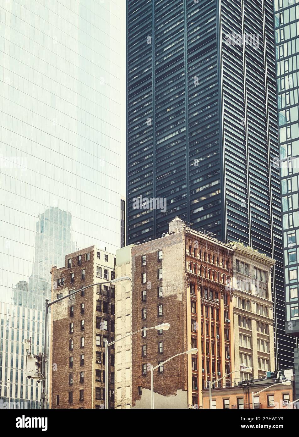 Vieux bâtiments de maison de ville entre les gratte-ciels modernes à New York, rétro couleur tons image, Etats-Unis. Banque D'Images