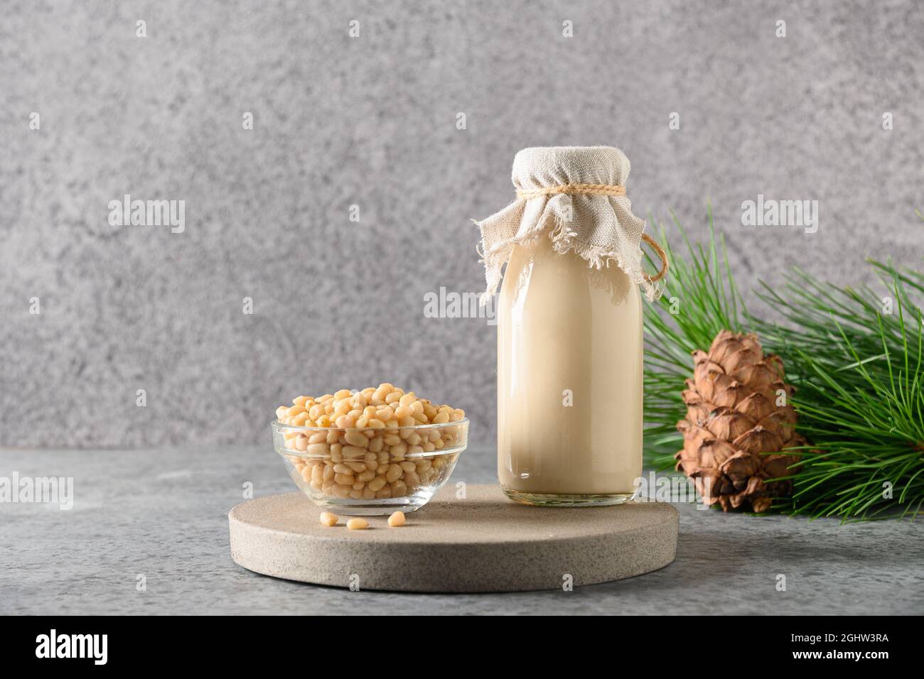 Lait de noix de cèdre vegan en bouteille sur fond gris. Lait de remplacement non laitier. Boisson végétarienne saine. Banque D'Images