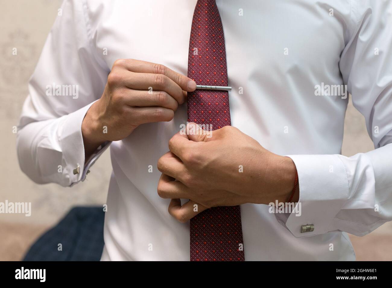 Le marié ajuste le clip sur la cravate bordeaux, emballant pour le mariage  Photo Stock - Alamy
