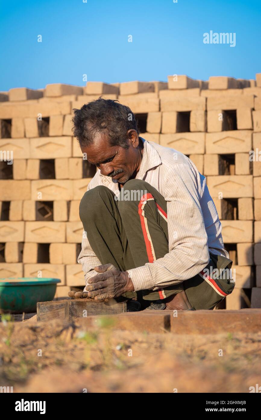 TIKAMGARH, MADHYA PRADESH, INDE - 11 AOÛT 2021 : homme indien faisant des briques à la main à l'aide d'un moule et d'argile humide. Banque D'Images