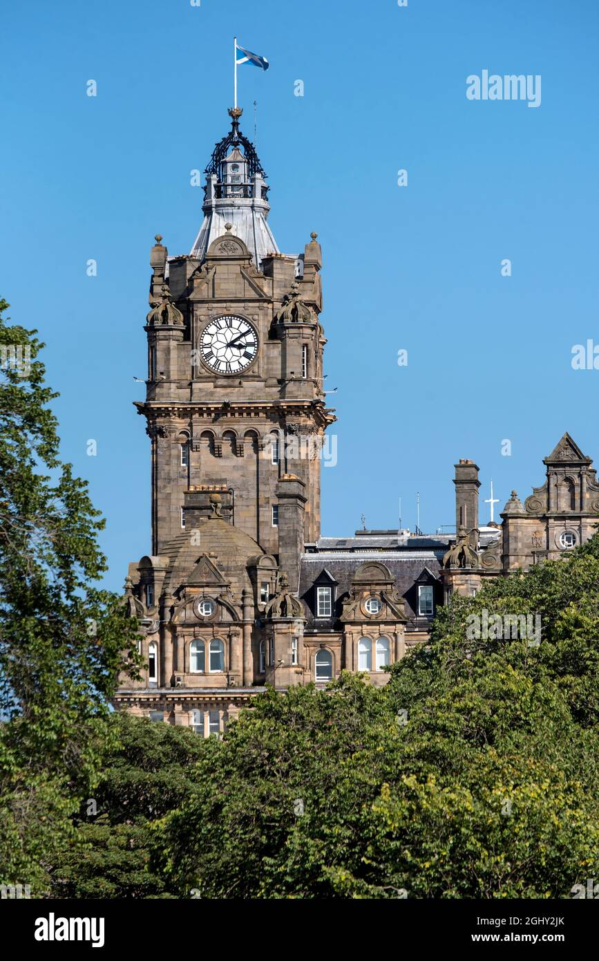 Le clocher de l'hôtel Balmoral vu à travers les arbres dans Princes Street Gardens, Édimbourg, Écosse, Royaume-Uni. Banque D'Images Le clocher de l'hôtel Balmoral vu à travers les arbres dans Princes Street Gardens, Édimbourg, Écosse, Royaume-Uni. Banque D'Images