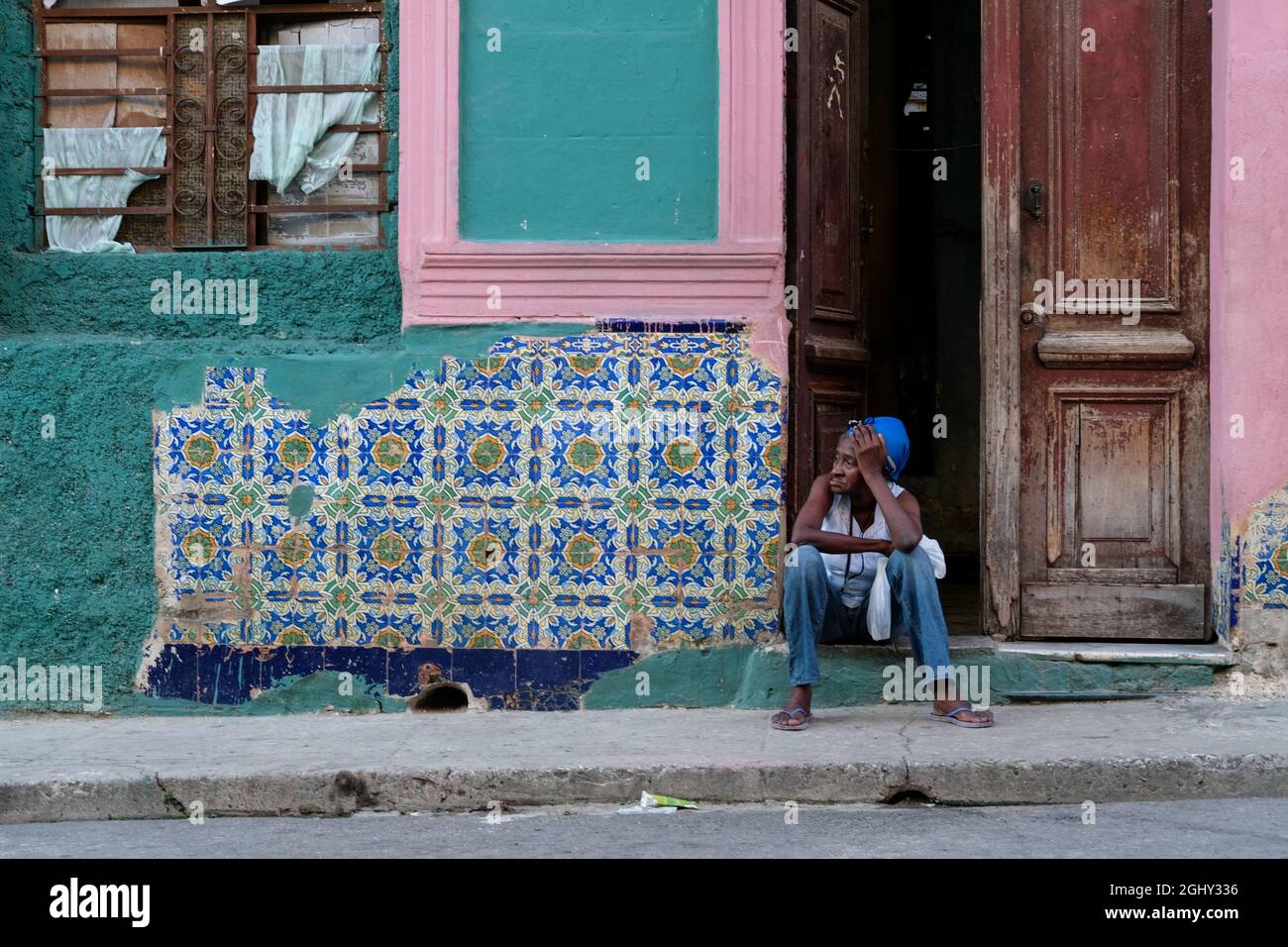 Une femme est assise près de la route à la Havane, Cuba. Banque D'Images