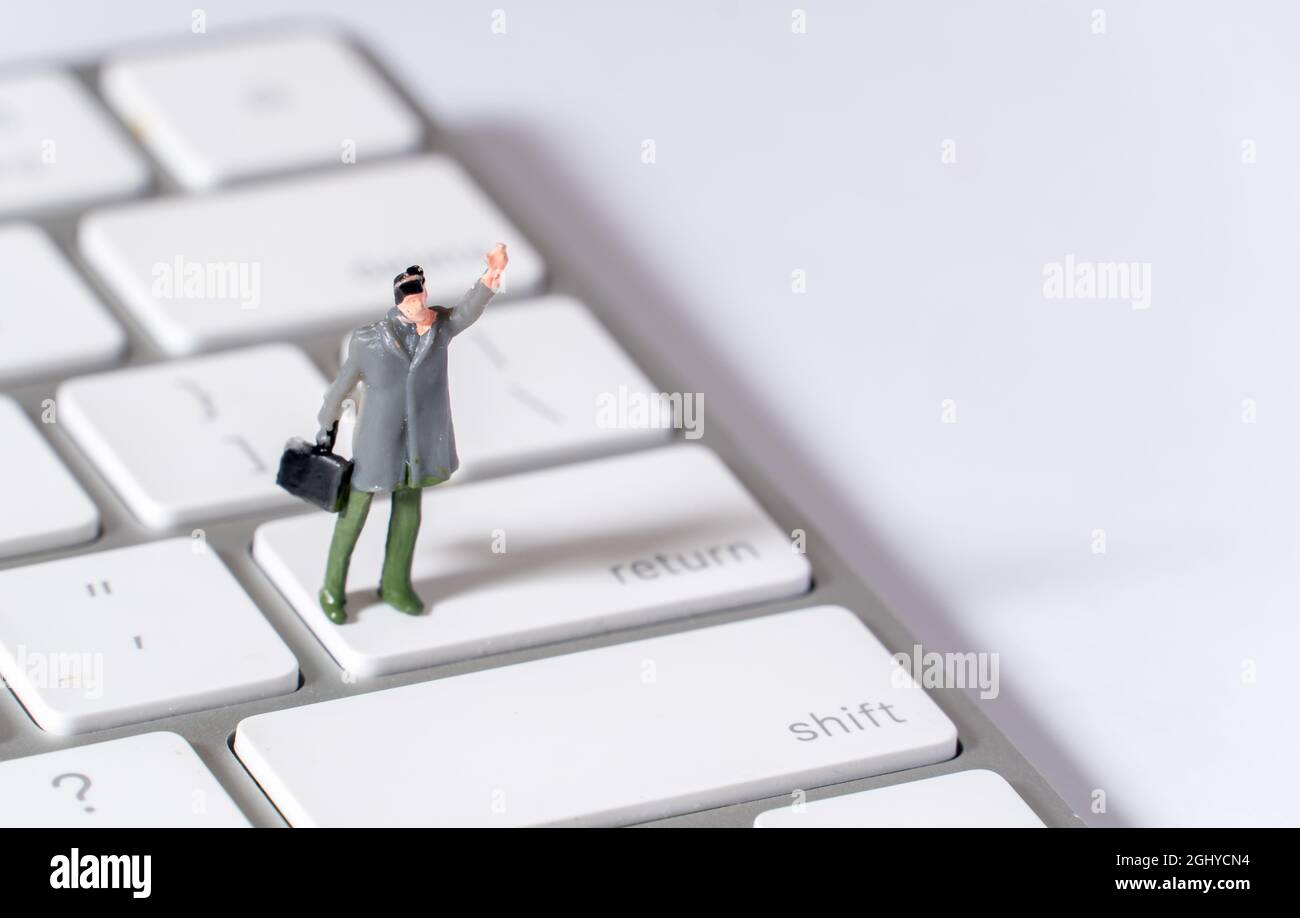 Figurine miniature mâle avec chapeau et porte-documents sur la clé de retour Banque D'Images