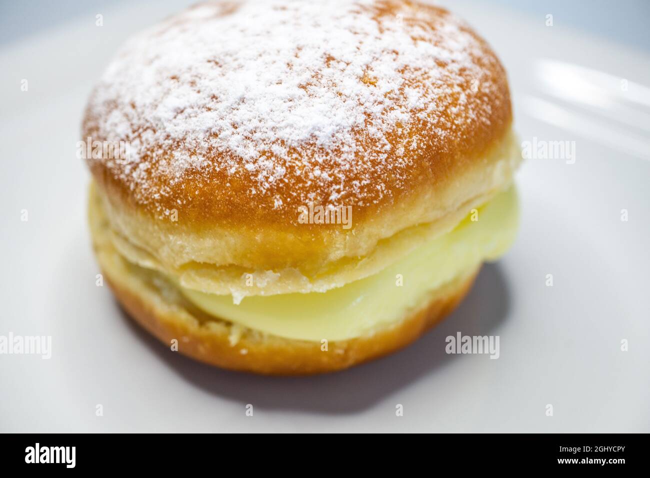 gros plan de la pâte berlinère sur une assiette blanche - plat de pâtisserie allemand avec garniture à la crème vanille Banque D'Images