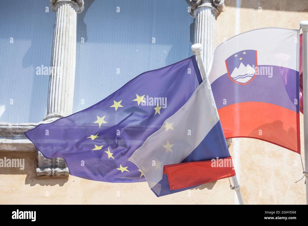 Photo du drapeau de la Slovénie et du drapeau de l'UE ensemble devant un bâtiment de Ljubljana. La Slovénie est l'un des principaux membres de l'Europe Banque D'Images