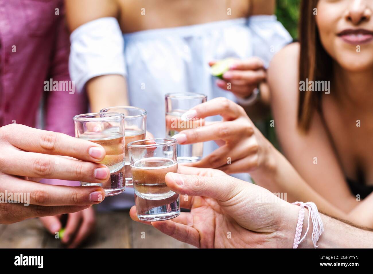 tequila shot, Réunion de jeunes amis latins pour prendre un verre à tequila ou des boissons mezcal pour faire un toast sur la terrasse du restaurant au Mexique en Amérique latine Banque D'Images