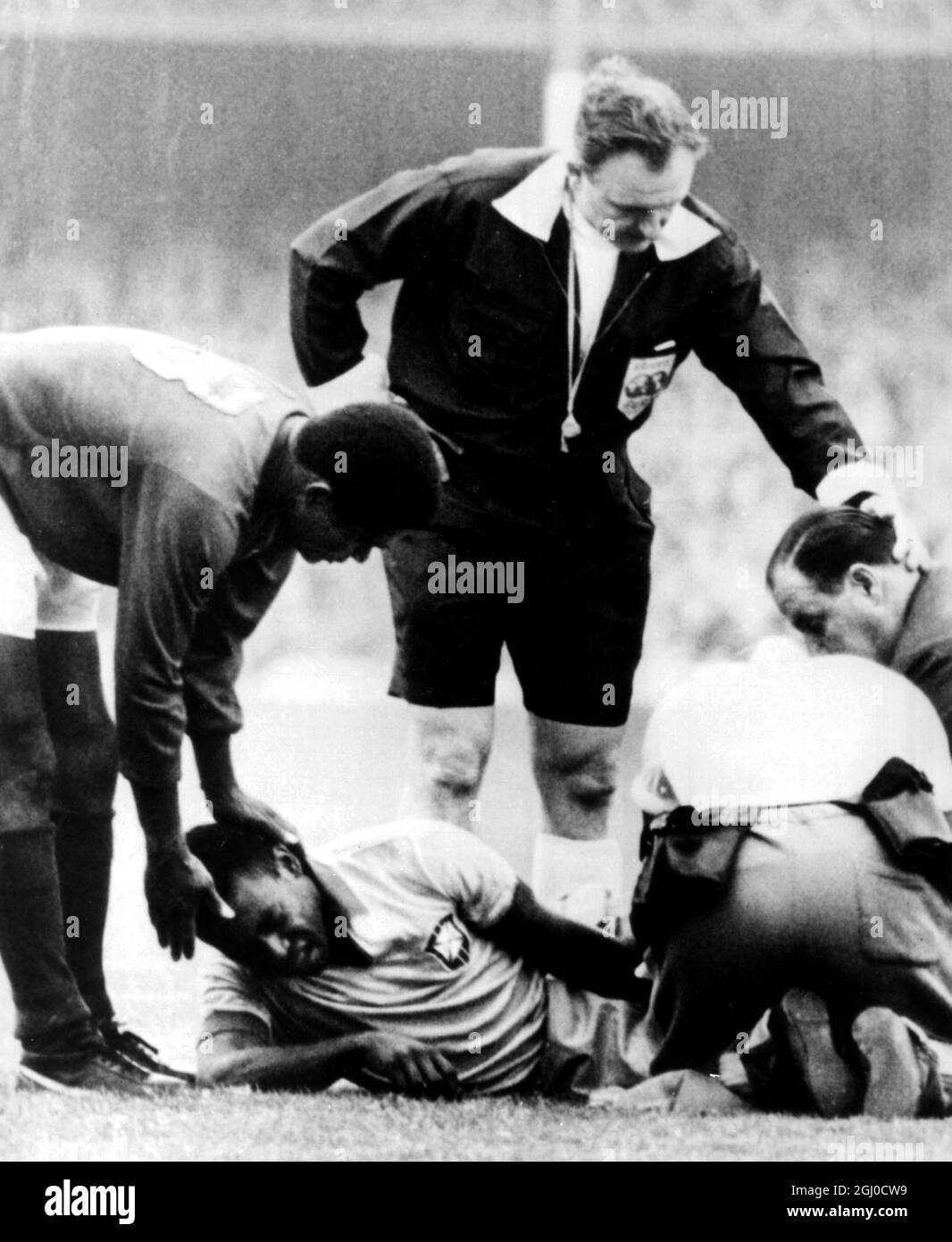 Coupe du monde 1966 Brésil / Portugal Pele, se trouve blessé sur le terrain  alors qu'Americo et le Dr Gosling de l'équipe brésilienne lui assistent.  Eusebio du Portugal (No.13) est vu en