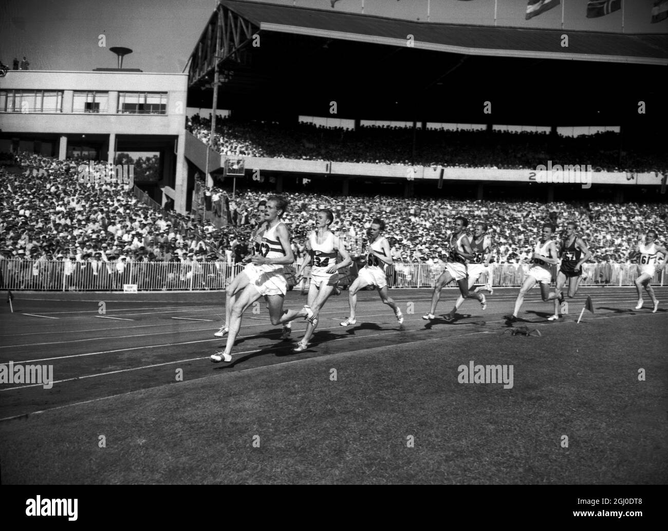 Jeux olympiques de 1956, Melbourne arrondissant le dernier ben de l'événement de 1500m Britains Brian Hewson (162) est en tête, mais sur le point d'être dépassé par l'Irlande Ron Delaney (102) le gagnant final à un record 3:41.2 seconde a été Walter Richtzenhain d'Allemagne et John Landy d'Australie a pris la troisième place. 1er décembre 1956. Banque D'Images
