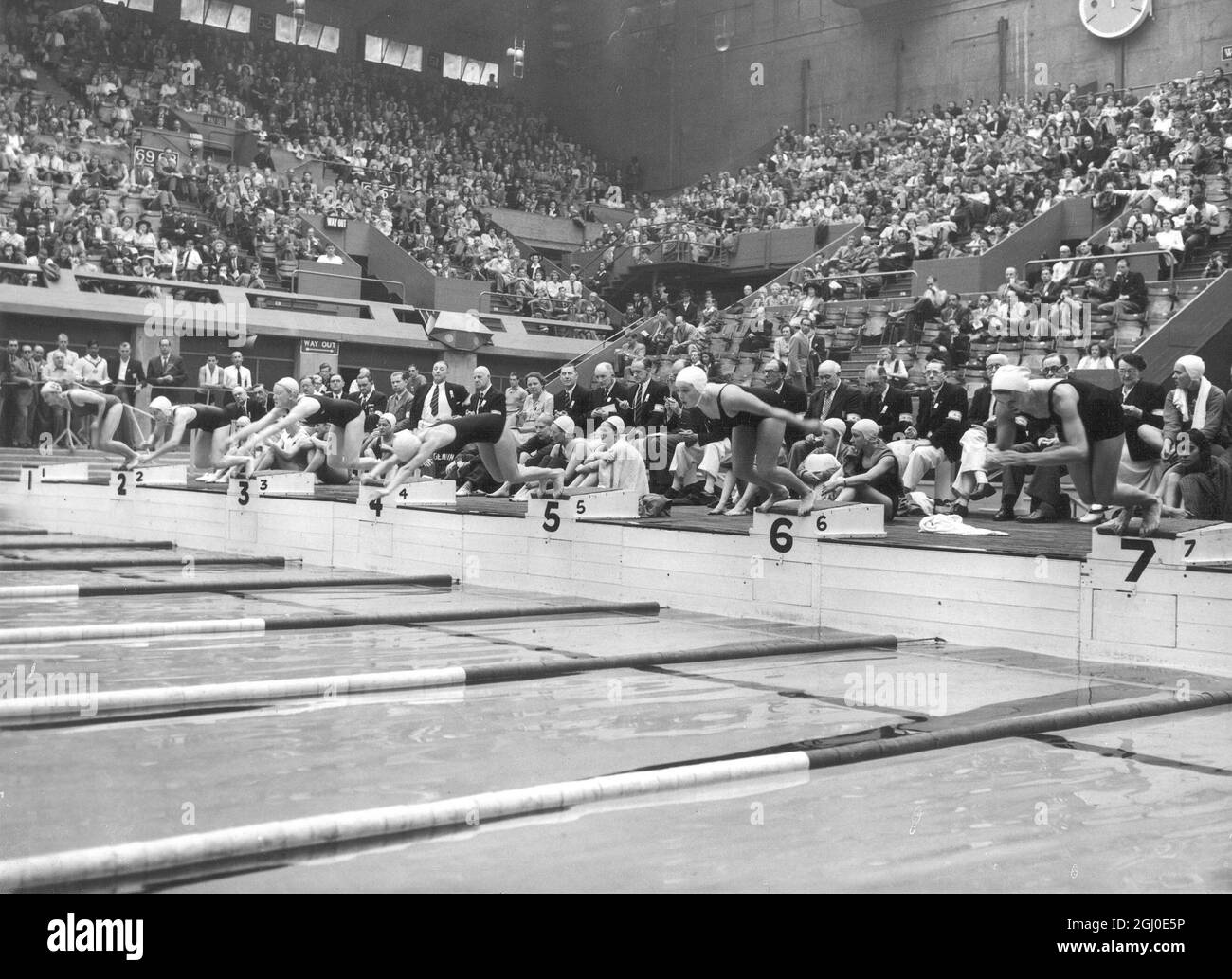 Jeux Olympiques de 1948 -Heat l'un des relais de natation de 400m pour femmes à l'Empire Pool, Wembley, Londres - dans la première semaine, la piscine Empire a été utilisée pour la natation, la plongée et les épreuves de water-polo , Dans la deuxième semaine, la piscine a été drainée et une scène a été placée sur le bassin afin que les événements de boxe puissent être organisés dans la même arène le 4 août 1948 Banque D'Images