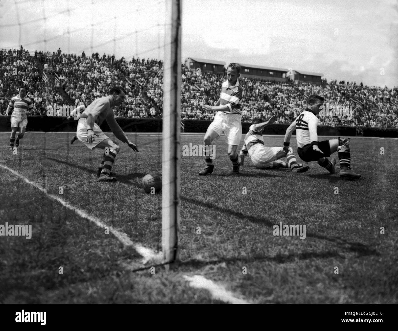 Belfast Celtic v Philadelphia Nationals Belfast Celtic gardien de but, Kevin McAlinden regarde le ballon passer dans le but, comme la moitié centrale du Belfast Celtic, Charlie Currie regarde sur. 1er juin 1949. Banque D'Images