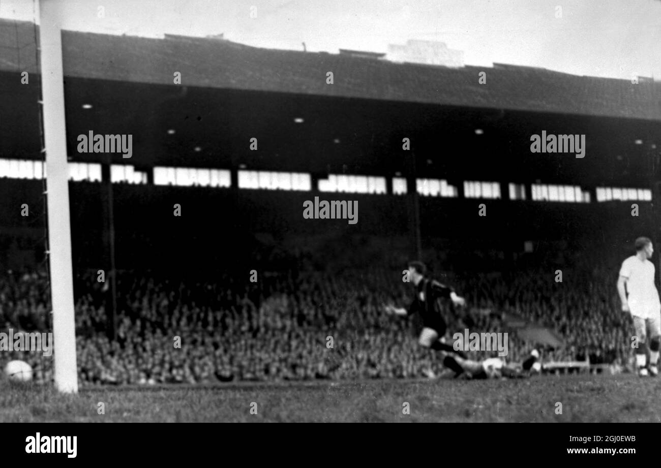 L'avant du centre de Milan Juan Schiaffino se précipite au-dessus du gardien de but de Manchester United , Harry Gregg alors que la balle entre dans le filet marquant le premier but pour Milan dans la demi-finale de la coupe d'Europe de Manchester United / Milan à Old Trafford. 8 mai 1958. Banque D'Images