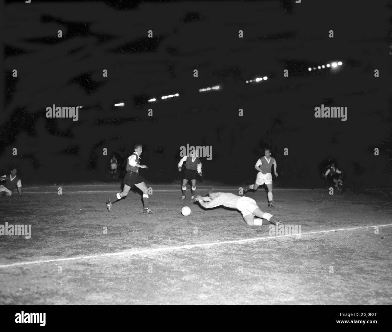 Reims v Hibernian français avançant Glovacki (à gauche) et Leblond menacent le gardien de but écossais plus jeune, alors que le dos complet McFarlane (à droite) s'étend pendant la demi-finale de la coupe d'Europe au stade du Parc des Princes à Paris. Reims a gagné 2-0. 6 avril 1956. Banque D'Images
