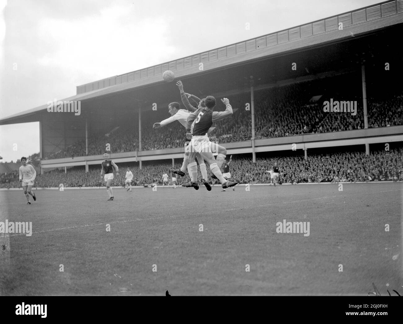 West Ham United v Leeds United Alan Peacock (à gauche) de Leeds United, le gardien de but West Ham Jim Standen (au centre) et Dave Bickles de West Ham (n°5) sautent pour le ballon pendant le match à Upton Park entre Leeds United et West Ham United le 28 août 1965 Banque D'Images