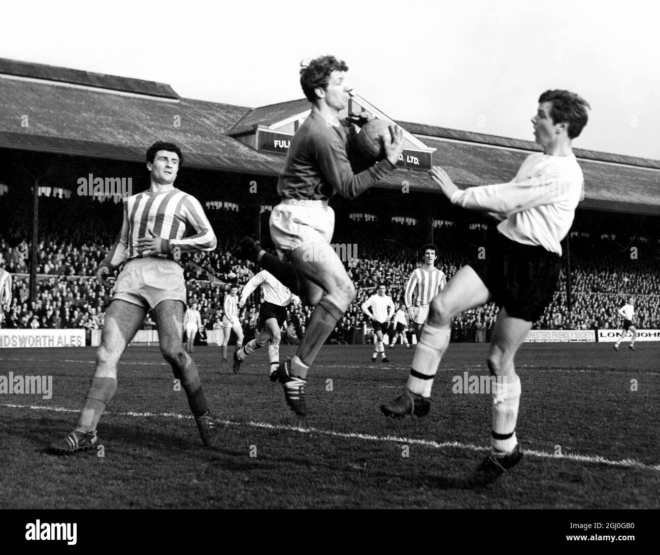 Fulham v Sunderland Montgomery, le gardien de but de Sunderland se précipite pour rassembler le ballon, battant Barrett (à droite) le Fulham à l'extérieur-à gauche. Sur la gauche se trouve Hurley, la moitié centrale du Sunderland. 19 mars 1966 Banque D'Images