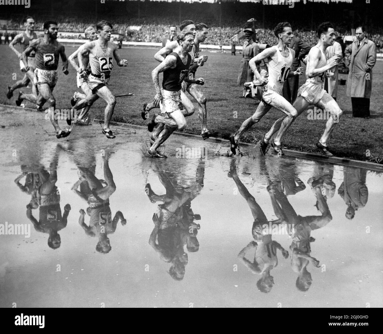 Une grosse baisse a rendu les conditions difficiles pour les concurrents le dernier jour des Jeux britanniques qui se sont tenus à White City. Voici le champ vu lors de l'événement One Mile. 2 juin 1952 Banque D'Images