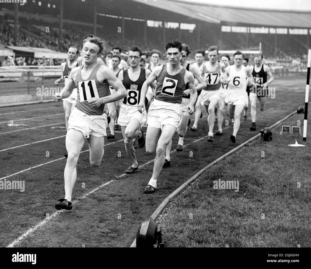 Jeux britanniques de 1954 le début de l'épreuve de 3 miles à White City - Ahleles sont N. Wilson (No.11) P C Perry (No.8) et S. Eldon (No.2). 5 juin 1954 Banque D'Images