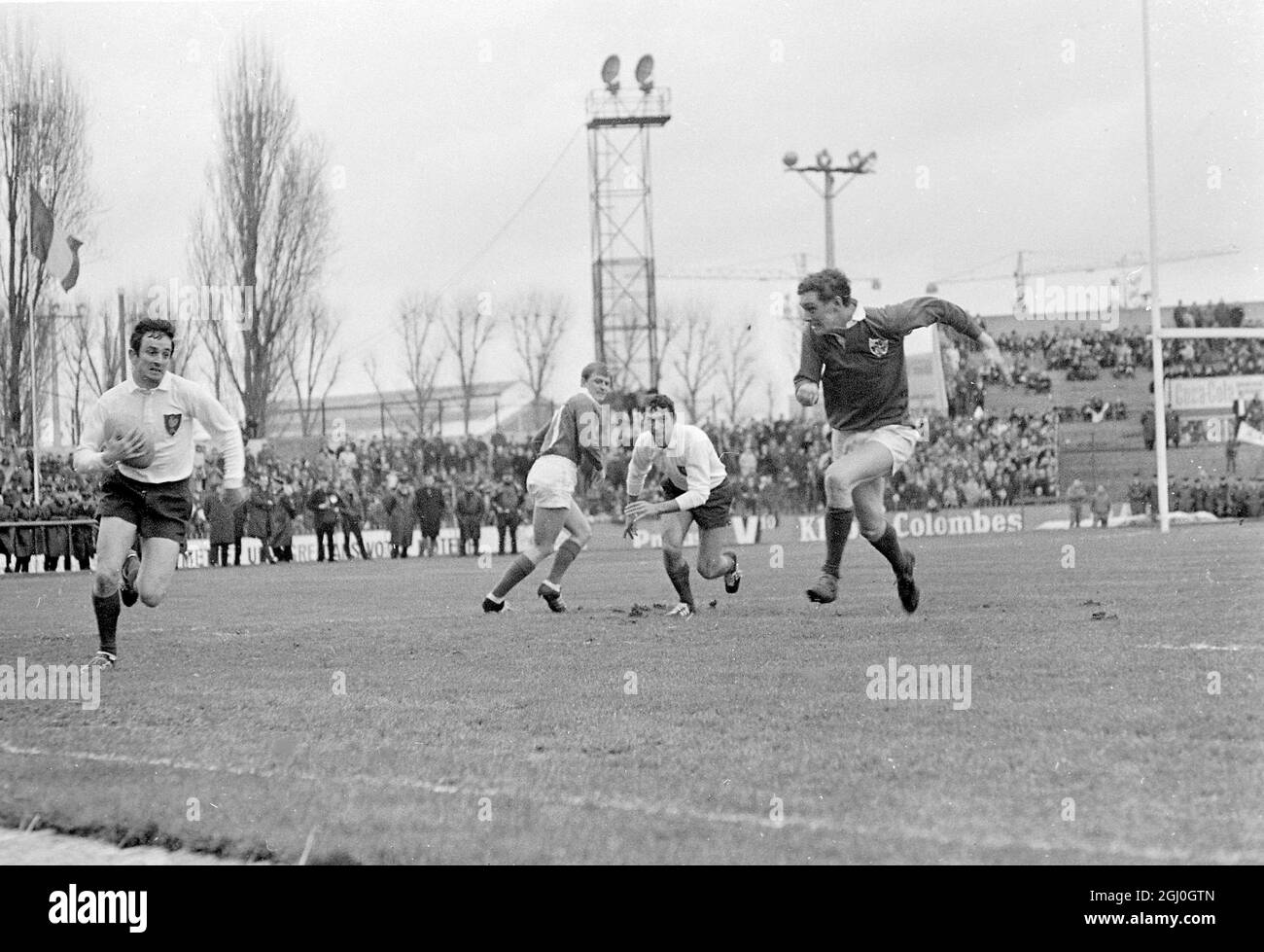 Le Français Pierre Villepreux (à gauche) court avec le ballon, le coéquipier Christian Carrere (au centre) se prépare au sauver du joueur irlandais (à droite) lors de l'Union internationale de rugby des cinq nations à Paris. 29 janvier 1968 Banque D'Images