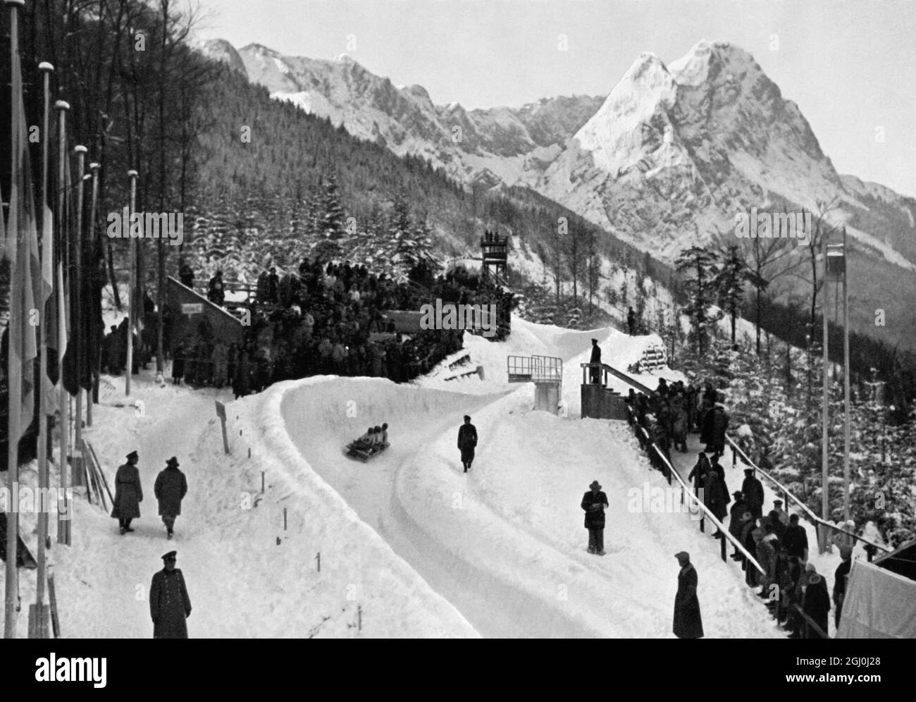 Des bobsleigh olympiques courent avec le merveilleux Waxensteinen en arrière-plan. Banque D'Images