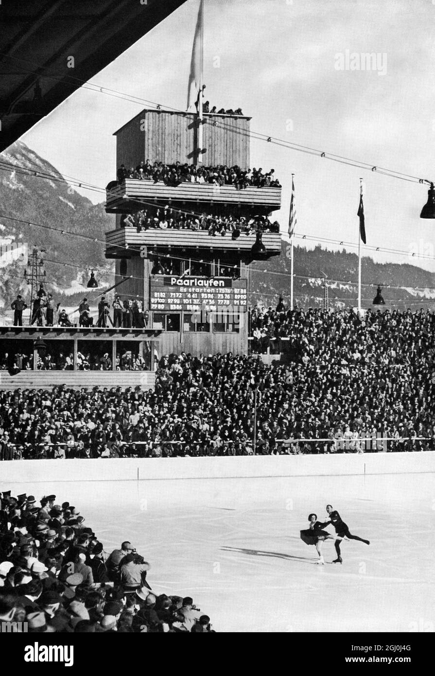 Jeux olympiques de 1936 - tout le monde s'est avéré voir le triomphe de la paire de maîtres Mazie Herber et Ernst Baier - patineurs de paires. Ernst Baier (né le 27 septembre 1905 à Zittau, Saxe, Allemagne - décédé le 8 juillet 2001 à Garmisch, Bavière, Allemagne) était un patineur de la figure allemande. Il est devenu champion olympique par paires en 1936 avec Maxi Herber. Les patineurs ont également remporté plusieurs championnats du monde et d'Europe. ©TopFoto Banque D'Images