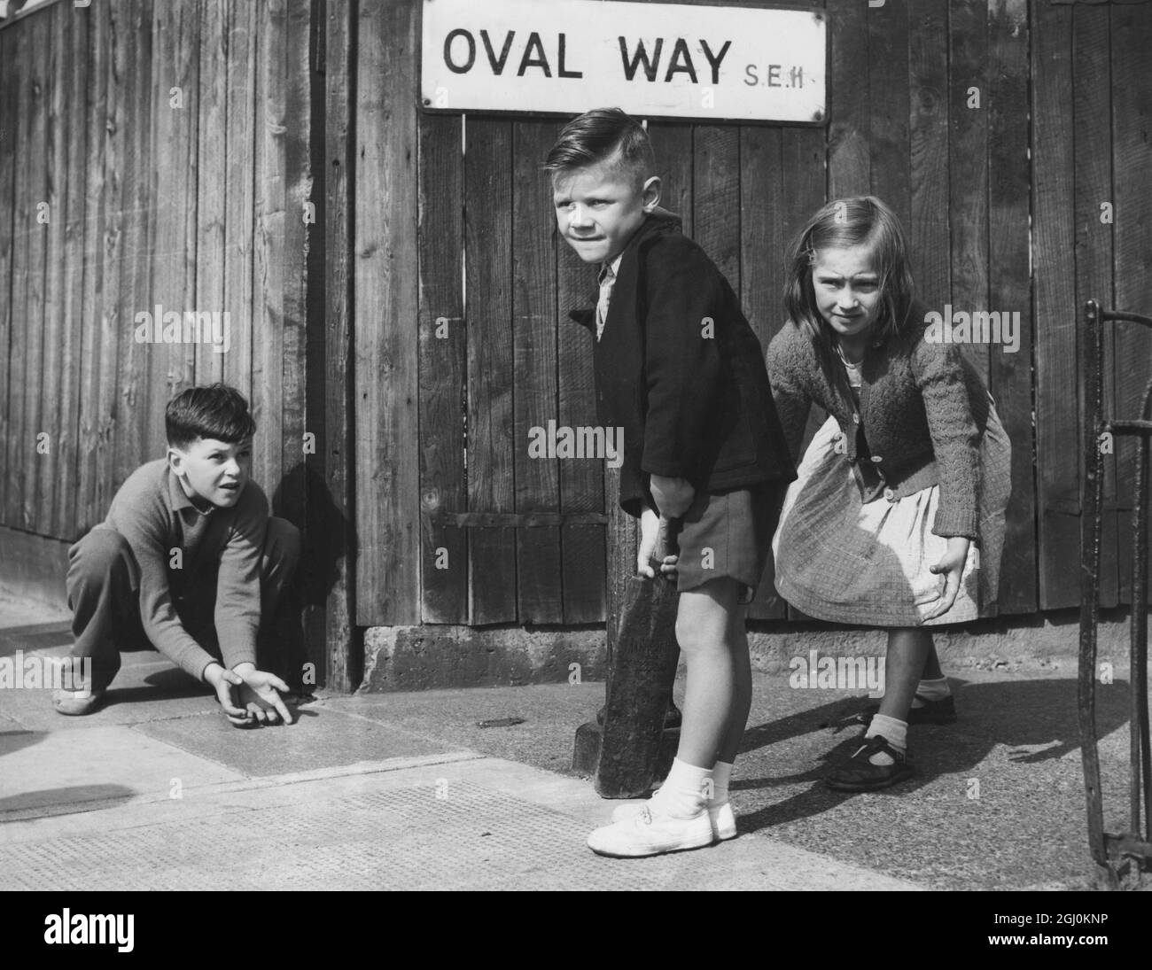 Enfants jouant un match de cricket dans la rue - Oval Way est le panneau de route derrière eux - août 1957 ©TopFoto Banque D'Images