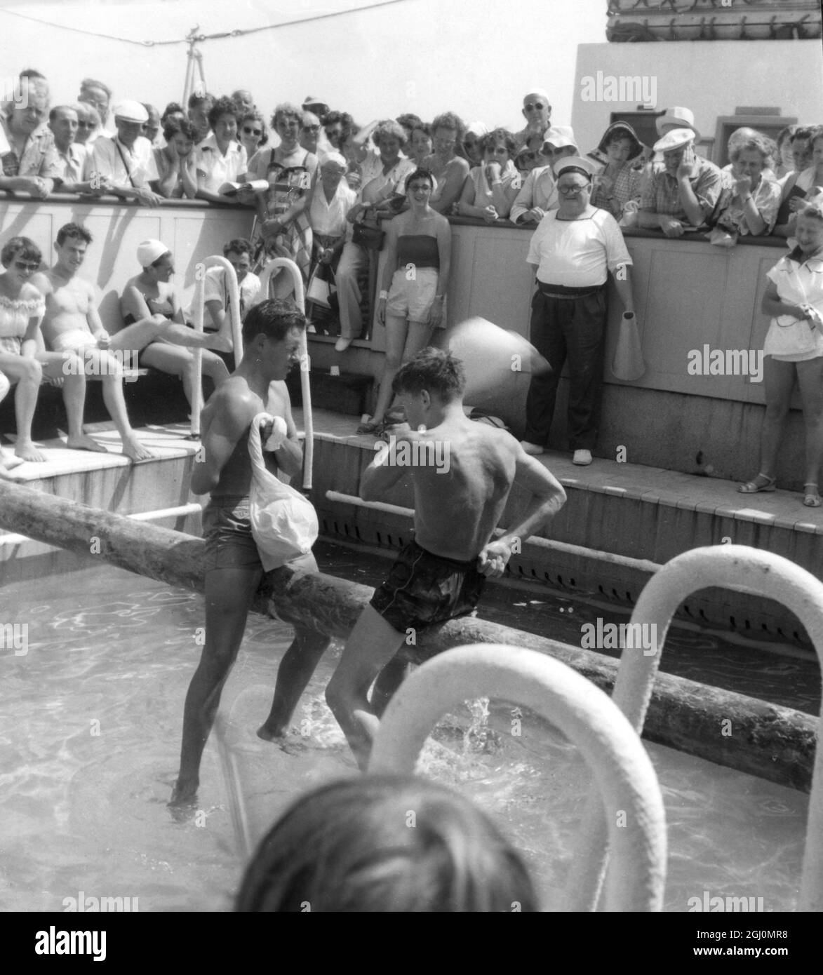 Deux hommes jouent à un jeu de piscine avec de nombreux passagers qui les regardent autour d'eux lors d'une croisière en Méditerranée Banque D'Images