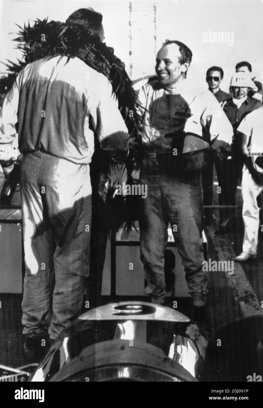 John Surtees félicite Dan Gurney, lauréat du Grand Prix mexicain de Costa Mesa, Californie. 26 octobre 1964 Banque D'Images