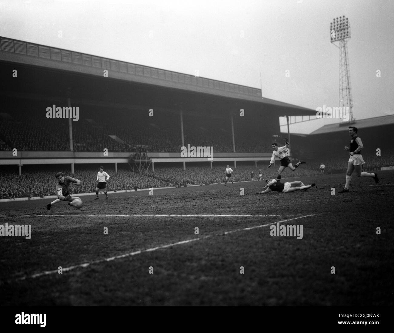 John Connelly de Burnley (à droite) marque le premier but de Burnley dans son match de sixième manche de la coupe FA contre West Ham . Sur le sol se trouve le Burkett de West Ham et (à gauche) est le gardien de but West Ham Jim Standen , ne pas arrêter le tir . 29 février 1964 Banque D'Images