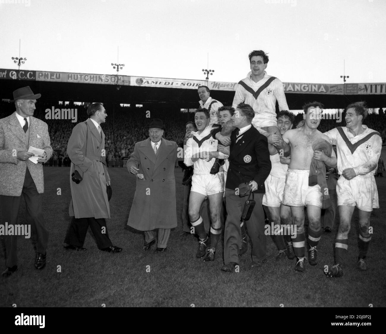 Le capitaine de l'équipe de rugby de Grande-Bretagne Dave Valentine est épaulé sur le terrain à Paris après que la Grande-Bretagne ait vaincu la France par 16 points à 12 dans la finale de la coupe du monde de rugby 15-11-1954 Banque D'Images