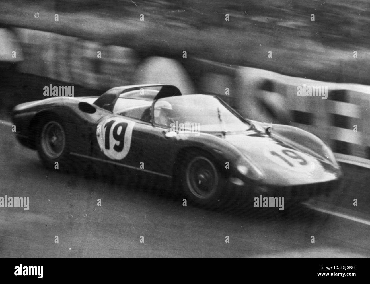 Surtees chauffe . Le Mans , France ; pilote britannique , John Surtees prend sa Ferrari italienne en vitesse sur la piste pendant les essais de la célèbre course d'endurance le Mans de 24 heures , qui commence plus tard . Surtees a déjà pointé la vitesse moyenne la plus rapide en pratique . 20 juin 1964 Banque D'Images