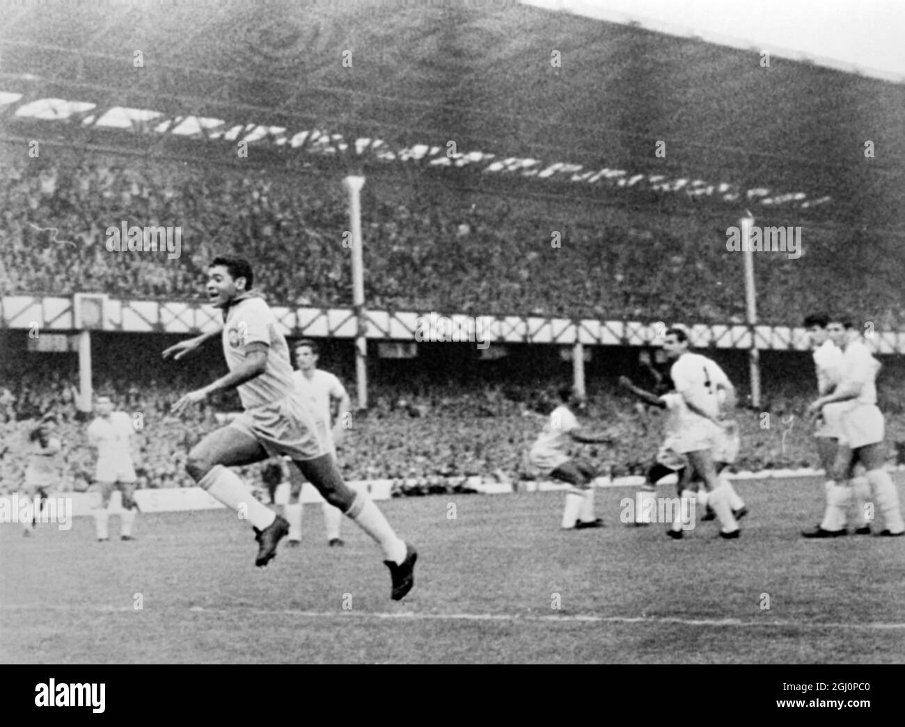 Le premier but du Brésil , et les Brésiliens jubilants , avec leur joueur Garrincha (à gauche) se précipitent vers l'avant , regardés par des Bulgares à la fois blanches et découragés , Goodison Park , Liverpool , Angleterre , domicile du club de football d'Everton à Liverpool . Le Brésil a battu la Bulgarie deux buts à zéro ce soir dans le jeu d'ouverture du groupe trois jouer au championnat du monde de football . Pele et Garrincha ont marqué pour le Brésil . 12 juillet 1966 Banque D'Images