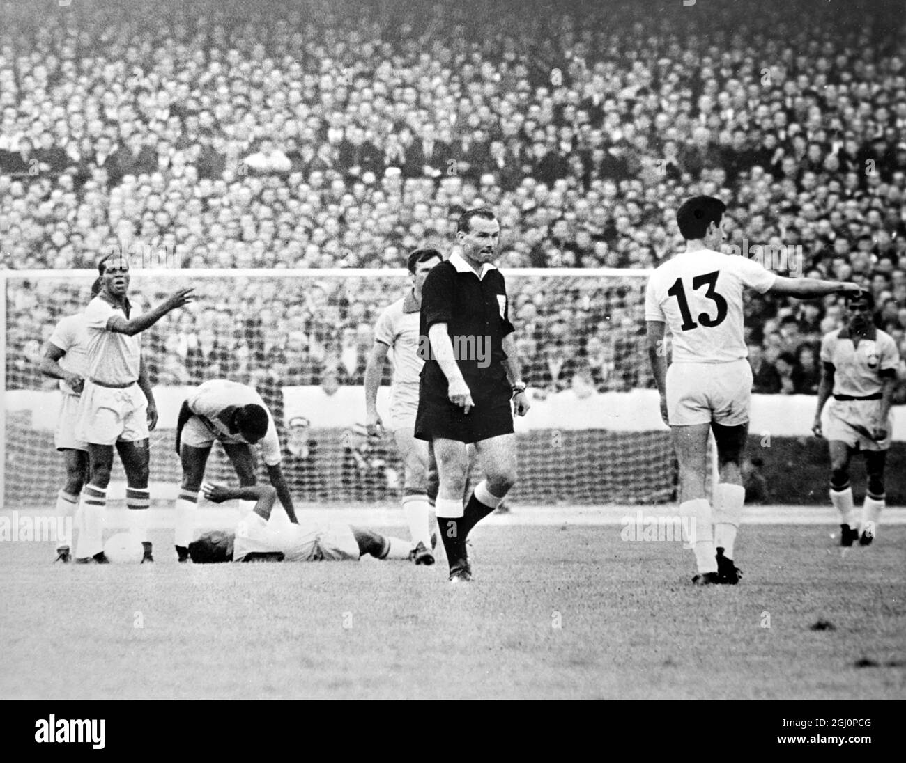 Pele blessé . Liverpool , Angleterre : le Pele du Brésil est photographié couché blessé alors que d'autres joueurs se crossent autour de leur match de la coupe du monde hier soir contre la Bulgarie . Identifié ici est le Dimiter bulgare Yakimov ( No 13 ) . Le résultat du match était 2 - 0 pour le Brésil . 13 juillet 1966 Banque D'Images