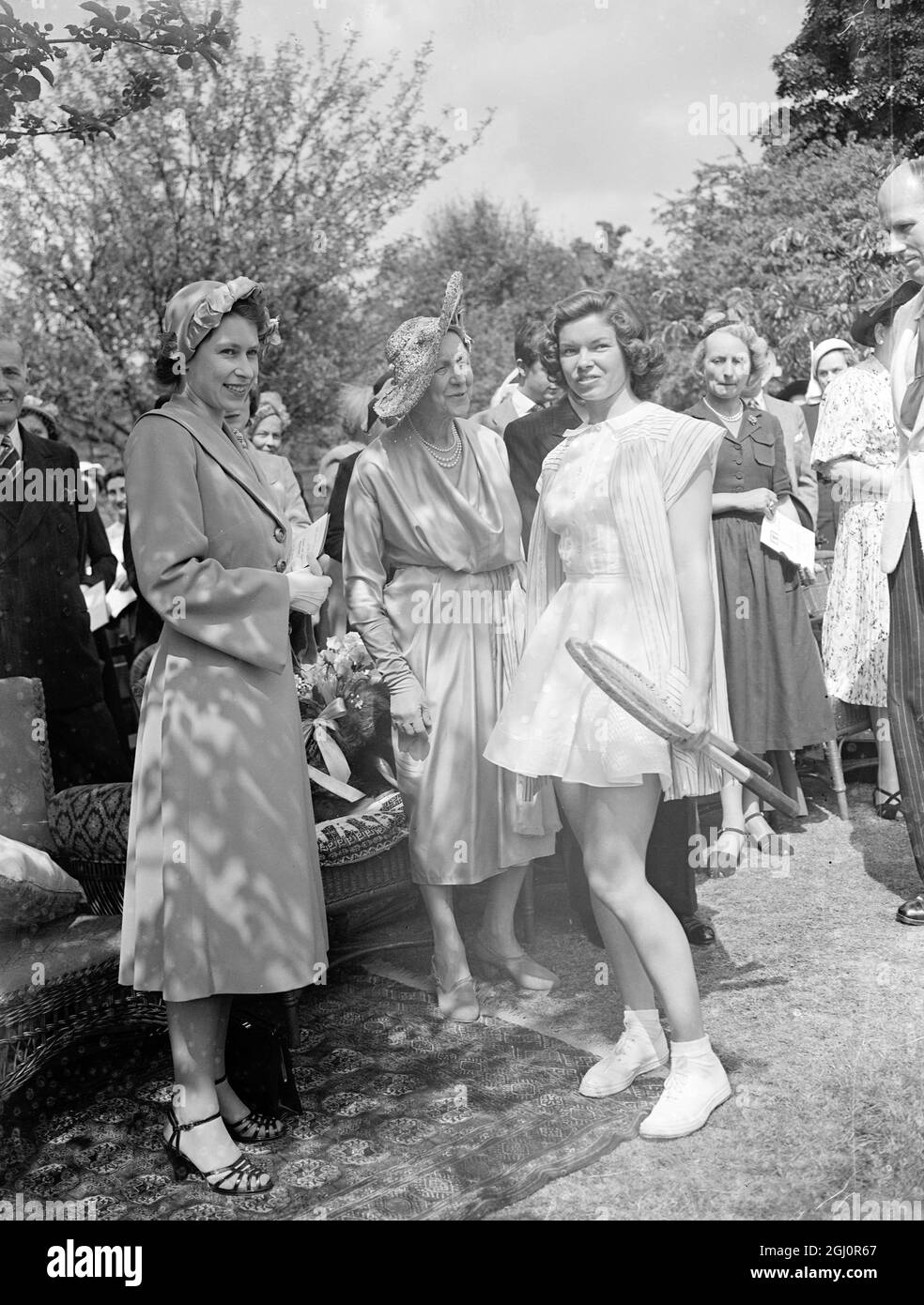 HRH la princesse Elizabeth a assisté aux matchs de l'exposition annuelle de tennis sur gazon tenus par Lady Crosfield à l'aide de la National Children's Palyground Association au 41 Highgate West Hill , Londres , N6 . Vu ici Miss Beverly Baker , joueur de tennis des Etats-Unis parle avec la princesse Elizebeth . Au centre est Lady Crossfield . 20 juin 1951 Banque D'Images